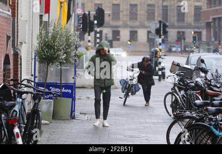 Amsterdam, pays-Bas. 11 mars 2021. Les membres du public marchent avec difficulté contre le vent lors d'une tempête le 11 mars 2021 à Amsterdam, pays-Bas. L'Institut néerlandais de météorologie KNMI a émis un avertissement météorologique jaune pour le pays avec des vents forts et des rafales jusqu'à des vitesses de vents allant jusqu'à 80 à 100 km par heure. (Photo de Paulo Amorim/Sipa USA) Credit: SIPA USA/Alay Live News Banque D'Images