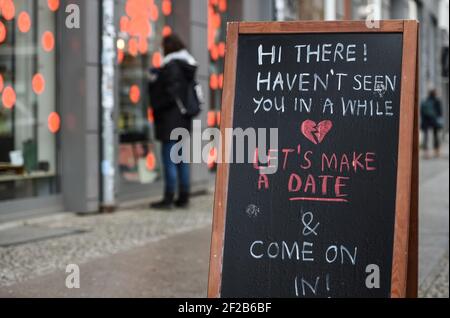 Berlin, Allemagne. 11 mars 2021. Devant un magasin, il y a un panneau qui dit « Bonjour! Je ne vous ai pas vu depuis un certain temps. Faisons une date et entrez ! ». Depuis 09.03.2021, les premiers clients sont de nouveau autorisés à magasiner en magasin sur rendez-vous. Credit: Kira Hofmann/dpa-Zentralbild/dpa/Alay Live News Banque D'Images