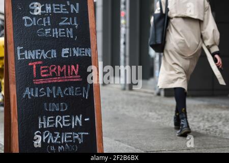 Berlin, Allemagne. 11 mars 2021. Devant un magasin, il y a un panneau indiquant 'chee'n dich zu sehen, einfach ein Termin ausmachen und herspaziert'. Depuis 09.03.2021, les premiers clients sont de nouveau autorisés à magasiner en magasin sur rendez-vous. Credit: Kira Hofmann/dpa-Zentralbild/dpa/Alay Live News Banque D'Images