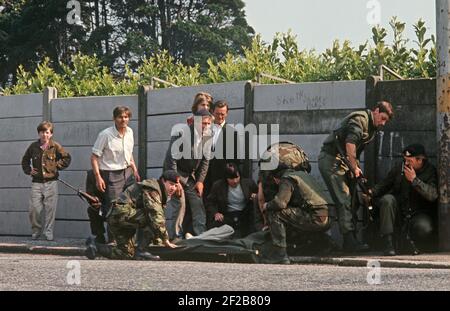 BELFAST, ROYAUME-UNI - JUIN 1972. Soldats et civils de l'armée britannique qui se sont pris en charge pendant l'attaque de sniper de l'IRA où une écolière a été blessée, Ballymurphy, West Belfast pendant les troubles, Irlande du Nord, années 1970 Banque D'Images