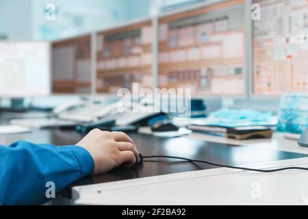 L'ingénieur contrôle le travail du processus technologique de production d'énergie devant les moniteurs, tiret la souris PC. Contrôle industriel tec Banque D'Images