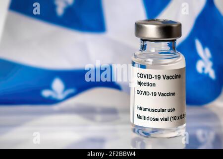 Flacon du vaccin Covid-19 devant le drapeau du Québec Banque D'Images