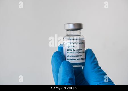 Montréal, CA - 4 mars 2021 : main dans un gant bleu contenant un flacon du vaccin AstraZeneca Covid-19 Banque D'Images