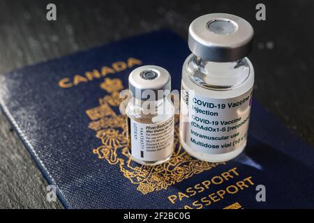 Montréal, CA - 8 mars 2021 : flacons de vaccins AstraZeneca et Pfizer BioNTech Covid-19 sur passeport canadien Banque D'Images