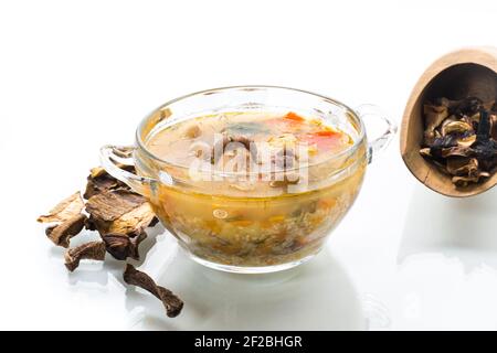 soupe de légumes végétarienne aux champignons porcini dans un bol en verre isolé sur fond blanc Banque D'Images