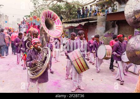 Inde, Mathura - bande de laiton recouverte de poudre colorée jouant dans la procession Holi à Mathura. Banque D'Images