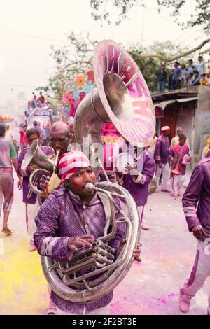 Inde, Mathura - bande de laiton recouverte de poudre colorée jouant dans la procession Holi à Mathura. Banque D'Images