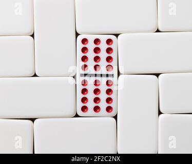 Double douze domino avec points rouges entourés de tuiles vierges Banque D'Images