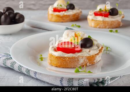 Bruschetta à la tomate, aux olives et à l'œuf de caille poché Banque D'Images