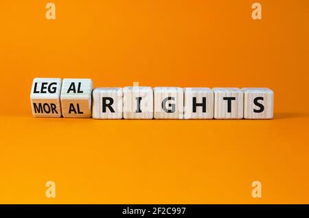 Symbole des droits moraux ou juridiques. Tourné cubes en bois et changé de mots droit moral aux droits légaux sur un beau fond orange. Affaires, morale ou Banque D'Images