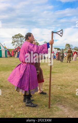 9 2014 mai Brisbane Australie - Homme vêtu de violet Robe ornée tenant une croix viking scandinave tardive à la vie Reconstitution de l'histoire avec peopl Banque D'Images