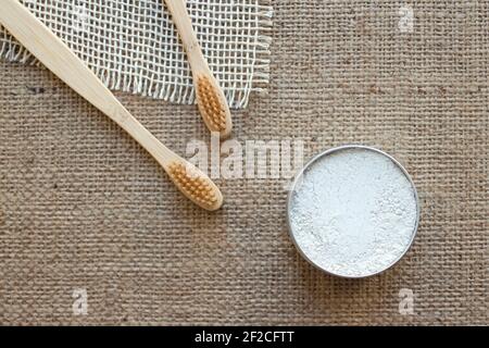 Deux articles essentiels de salle de bains naturels dans la maison zéro déchet - bambou brosses à dents et dentifrice de kaolin ou poudre de dent fait avec naturel ingrédients de style rustique Banque D'Images