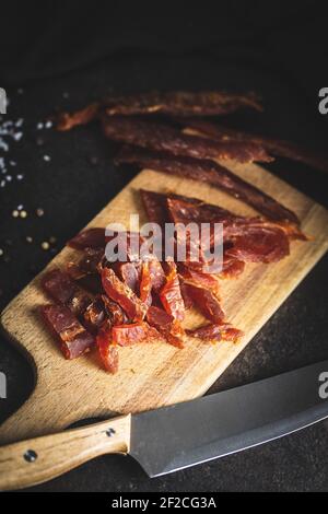 Viande de poulet séchée. Une viande savoureuse et savoureuse sur la planche à découper. Banque D'Images