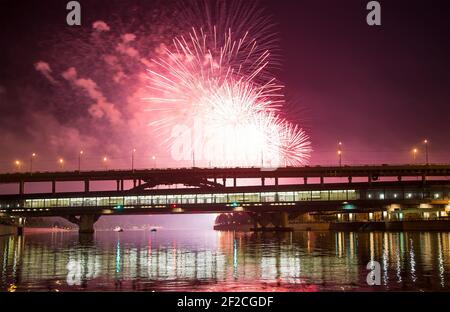 Feu d'artifice au-dessus de Moscou -- Rivière Moskva, pont Luzhnetskaya (pont Metro) à la lumière des lumières de nuit colorées. Moscou, Russie Banque D'Images