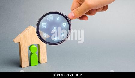 Realtor examine les maisons à travers une loupe. Examen du marché immobilier, recherche des meilleures offres basées sur les critères de prix, locat Banque D'Images