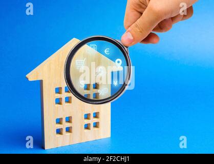 Realtor examine les maisons à travers une loupe. Examen du marché immobilier, recherche des meilleures offres basées sur les critères de prix, locat Banque D'Images