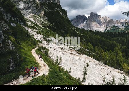 Groupe de randonneurs sur un chemin de gravier vers le lac Sorapis dans les Dolomites Banque D'Images