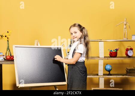 Fille écrit sur le tableau noir vierge, espace de copie Banque D'Images