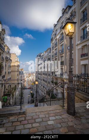 Paris, France - 02 26 2021 : quartier de Montmartre. Escalier en pierre avec lanternes éclairées Banque D'Images