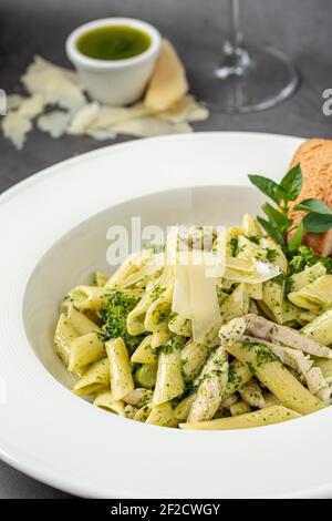 Penne avec sauce pesto, courgettes, pois verts et basilic. Banque D'Images