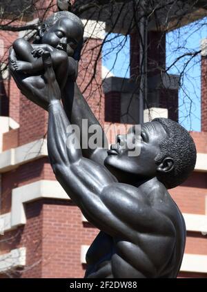 Atlanta, Géorgie, États-Unis. 10 mars 2021. Le révérend Martin Luther King Jr. Est honoré par 'Behold.' une sculpture de Patrick Morelli en face de l'église baptiste Ebenezer historique et en face de la nouvelle demeure de l'église. La sculpture, dévoilée par Mme Coretta Scott King le 11 janvier 1990, « révèle le rituel africain antique consistant à soulever un nouveau-né dans le ciel et à réciter ces mots: À”Voici la seule chose plus grande que vous,Ã ' selon la plaque du National Park Service qui l'accompagne. Le patrimoine du Dr KingÃs est célébré dans un parc historique national à Atlanta, en Géorgie, Banque D'Images