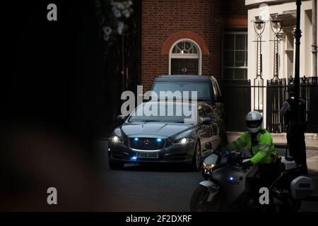 La police escorte le premier ministre hors de Downing Street. Banque D'Images