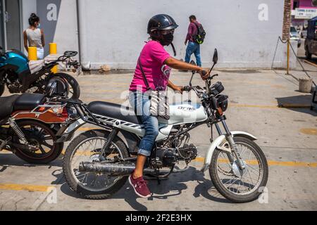 Pochutla, Mexique. 02 mars 2021. Une femme portant un masque facial fait une moto dans la rue de Pochutla.au Mexique, deuxième puissance économique en Amérique latine, plus de 800,000 emplois ont été perdus depuis le début de la crise de Covid19. Dans un pays où le taux de travail informel dépasse 55 %, les gens sont forcés de quitter leur foyer pour générer un revenu. Crédit : SOPA Images Limited/Alamy Live News Banque D'Images