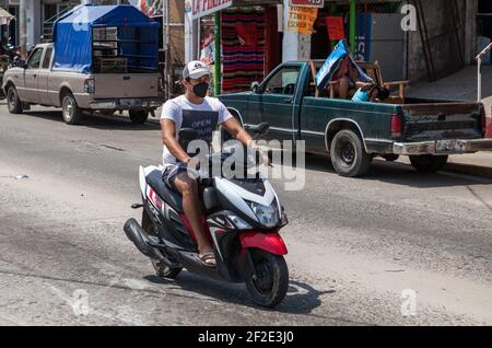 Pochutla, Mexique. 02 mars 2021. Un homme portant un masque facial fait une moto dans la rue de Pochutla.au Mexique, deuxième puissance économique en Amérique latine, plus de 800,000 emplois ont été perdus depuis le début de la crise de Covid19. Dans un pays où le taux de travail informel dépasse 55 %, les gens sont forcés de quitter leur foyer pour générer un revenu. Crédit : SOPA Images Limited/Alamy Live News Banque D'Images