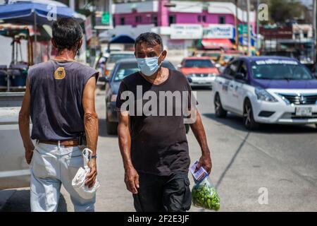 Pochutla, Mexique. 02 mars 2021. Un homme portant un masque facial marche dans la rue de Pochutla.au Mexique, deuxième puissance économique en Amérique latine, plus de 800,000 emplois ont été perdus depuis le début de la crise de Covid19. Dans un pays où le taux de travail informel dépasse 55 %, les gens sont forcés de quitter leur foyer pour générer un revenu. Crédit : SOPA Images Limited/Alamy Live News Banque D'Images