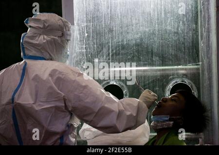 Un agent de santé effectue un test COVID-19 à l'intérieur d'un gymnase de la ville de Navotas, Manille, Philippines. Banque D'Images