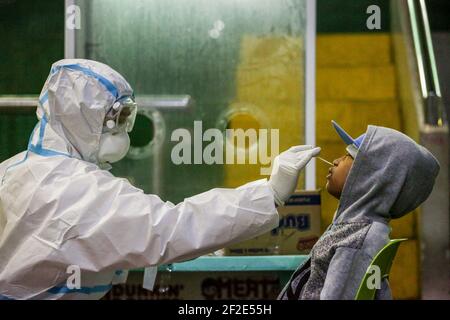 Un agent de santé effectue un test COVID-19 à l'intérieur d'un gymnase de la ville de Navotas, Manille, Philippines. Banque D'Images