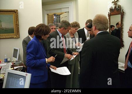 Le président George W. Bush examine un mémoire avec le personnel de la Maison Blanche à l'extérieur du Bureau ovale. Banque D'Images