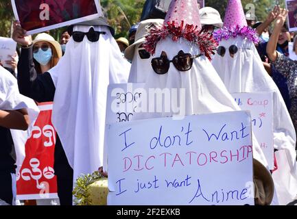 Myanmar. 12 février 2021. Les participants à une manifestation se rassemblent dans une rue portant des costumes fantômes et des panneaux indiquant « Je ne veux pas de dictature, je veux juste de l'anime ». Aussi choquante et froide que fut le coup d'État militaire au Myanmar début février, les manifestations qui ont débordé le pays peu de temps après ont été à l'origine colorées, créatives et imaginatives. (À dpa: 'De la robe de balle au bain de sang - la nouvelle génération du Myanmar défie la junta') Credit: Robert Bociaga/dpa/Alamy Live News Banque D'Images