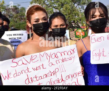 Myanmar. 12 février 2021. Les participants vêtues de robes de soirée prennent part à une manifestation, en tenant des panneaux indiquant « Save Myanmar ». Nous ne voulons pas de dictature militaire !!!' (Sauver le Myanmar. Nous ne voulons pas de dictature militaire !!!) Aussi choquante et froide que fut le coup d'État militaire au Myanmar début février, les manifestations qui ont débordé le pays peu de temps après ont été à l'origine colorées, créatives et imaginatives. (À dpa: 'De la robe de balle au bain de sang - la nouvelle génération du Myanmar défie la junta') Credit: Robert Bociaga/dpa/Alamy Live News Banque D'Images