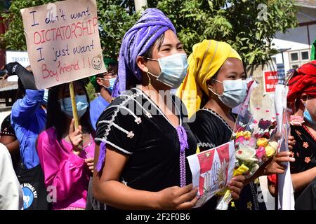 Myanmar. 12 février 2021. Les participants vêtues de robes de soirée prennent part à une manifestation, en tenant des panneaux indiquant « Je ne veux pas de dictature, je ne veux pas de petit ami ». Aussi choquante et froide que fut le coup d'État militaire au Myanmar début février, les manifestations qui ont débordé le pays peu de temps après ont été à l'origine colorées, créatives et imaginatives. (À dpa: 'De la robe de balle au bain de sang - la nouvelle génération du Myanmar défie la junta') Credit: Robert Bociaga/dpa/Alamy Live News Banque D'Images