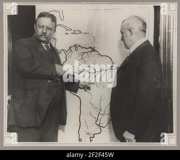 Le président Roosevelt en montrant une carte de l'Amérique du Sud vers la région d'examiner au cours de l'expédition scientifique au Brésil Roosevelt-Rondon comme un autre homme regarde sur Banque D'Images