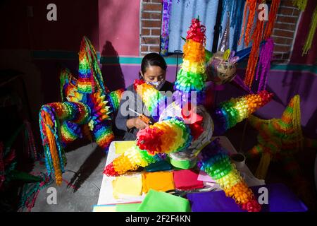 ACOLMAN, MEXIQUE - 7 MARS 2021 : une femme fabrique le pinata mexicain traditionnel, fabriqué à partir d'un pot d'argile enveloppé de papier multicolore, le pinata traditionnel prend la forme d'une étoile, avec sept points qui représentent les péchés mortels. Selon une ancienne tradition mexicaine le 7 mars 2021 à Acolman, au Mexique. Crédit : Ricardo Castelan Cruz/Groupe Eyepix/accès photo Banque D'Images