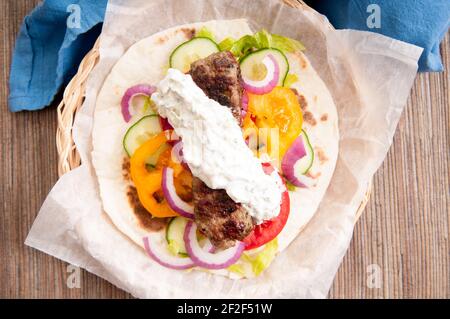 Pain plat délicieux wrap koobideh, brochette iranien avec des légumes frais et de sauce tzatziki Banque D'Images