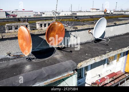 vieux plats de satellite rouillés sur le toit. Banque D'Images