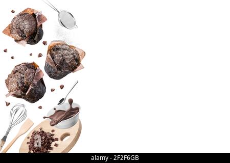 Muffins au chocolat ou petits gâteaux avec ensemble d'ustensiles de cuisine sur fond blanc. Copier l'espace. Banque D'Images