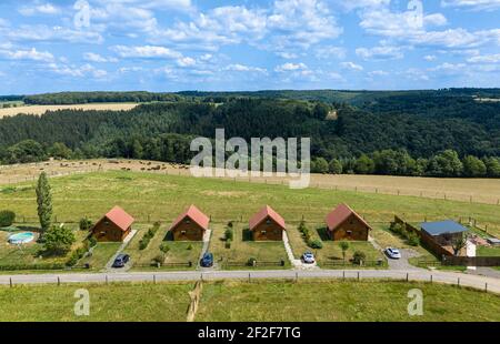 Vue aérienne sur un groupe de maisons modernes similaires dans la rangée. Pâturage avec des bisons et des bois en arrière-plan. Banque D'Images