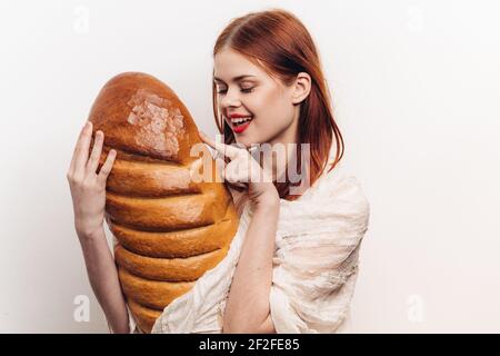 femme émotive avec le grand produit de farine de bourgeon pain fond clair Banque D'Images