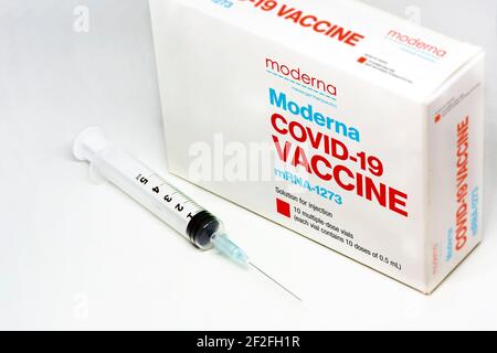 Cambridge, ma, Etats-Unis, 5 février 2021 : une seringue à côté de la boîte de vaccin Moderna Covid-19 isolée sur fond blanc. Santé et prévention. Banque D'Images