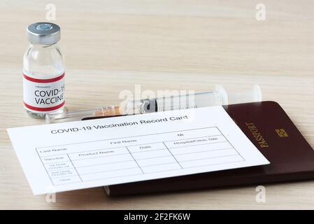 Passeport et fiche de vaccination pour les voyages après la vaccination contre le covid-19.seringue et flacon de vaccin contre le covid-19. Banque D'Images