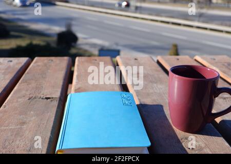 Agenda et tasse à café sur un bureau en bois à l'extérieur Banque D'Images