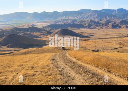 Paysage de montagne avec un vus se déplaçant le long d'une route de terre Banque D'Images