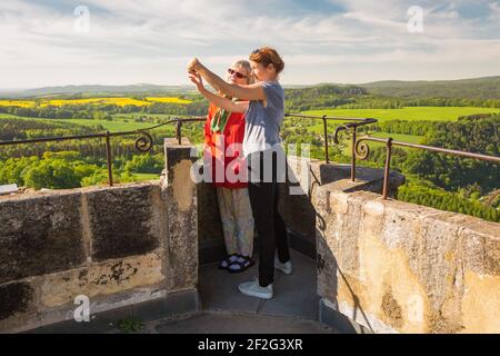 Vue latérale de la mère et de la fille - une femme âgée et une femme mûre à la forteresse de Koenigstein. Ils prennent un selfie avec un téléphone portable. Parc national de la Suisse saxonne, Allemagne Banque D'Images
