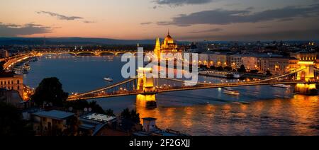 Le Parlement et les ponts de Budapest illuminée en soirée, Hongrie Banque D'Images