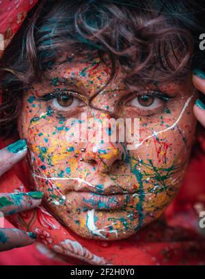 Gros plan Portrait d'une jeune femme brunette avec peinture multicolore pour le visage. Holi festival des couleurs, les gens. Banque D'Images