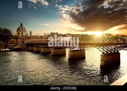 Vue sur le Pont des arts et de l'Institut de France à Paris au coucher du soleil Banque D'Images